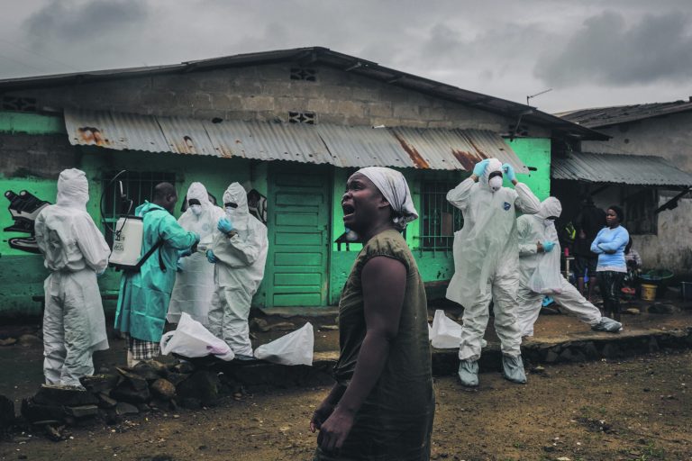 Sugulane leinab Punase Risti matmismeeskonna juures, mis valmistub ära viima Ofori Gweah’ surnukeha. Gweah suri ebolasse Monrovias Libeerias.