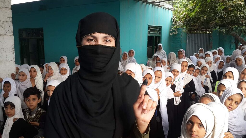 Fatima Zahra kooli õpetaja Arzo näitab tindist sõrmeotsa, mis viitab, et ta on valimas käinud. 2019. aasta presidendivalimised olid neljandad valimised, kus naised pärast Talibani võimulolekut osalesid. Naiste osalus valimistel on siiski madal, 33 protsenti 2018. aasta parlamendivalimistel. Üheks põhjuseks on kartus saada karistada. Pärast valimisi on alati juhtumeid, kus Taliban kontrollib inimeste sõrmeotsi ning nähes, et need on tindised, rakendab vägivalda.